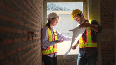 Mimarlar ve mühendisler, konut inşaatının ilerlemesini değerlendirmek için birlikte çalışırlar.