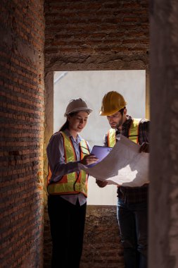 Mimarlar ve mühendisler, konut inşaatının ilerlemesini değerlendirmek için birlikte çalışırlar.