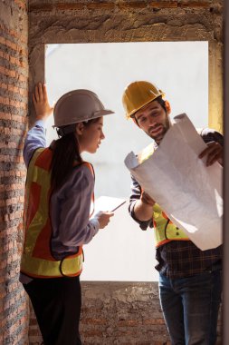Mimarlar ve mühendisler, konut inşaatının ilerlemesini değerlendirmek için birlikte çalışırlar.