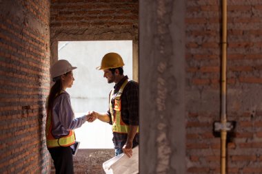 Mimarlar ve mühendisler, konut inşaatının ilerlemesini değerlendirmek için birlikte çalışırlar.