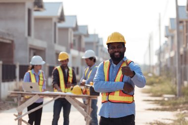 Mühendislerin portresi konut inşaatının ilerlemesini değerlendirmek için birlikte çalışıyor.