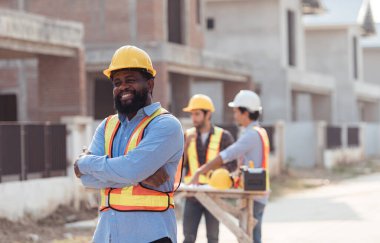 Mühendislerin portresi konut inşaatının ilerlemesini değerlendirmek için birlikte çalışıyor.
