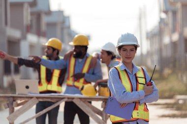Mühendislerin portresi konut inşaatının ilerlemesini değerlendirmek için birlikte çalışıyor.