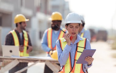 Mühendislerin portresi konut inşaatının ilerlemesini değerlendirmek için birlikte çalışıyor.