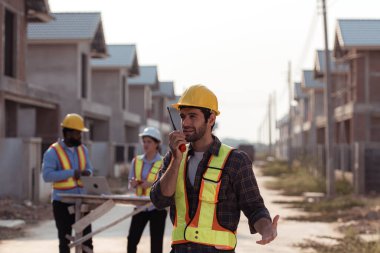 Mühendislerin portresi konut inşaatının ilerlemesini değerlendirmek için birlikte çalışıyor.