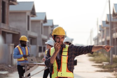 Mühendislerin portresi konut inşaatının ilerlemesini değerlendirmek için birlikte çalışıyor.