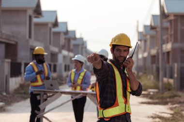 Mühendislerin portresi konut inşaatının ilerlemesini değerlendirmek için birlikte çalışıyor.