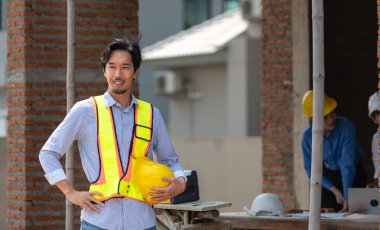 Mühendislerin portresi konut inşaatının ilerlemesini değerlendirmek için birlikte çalışıyor.