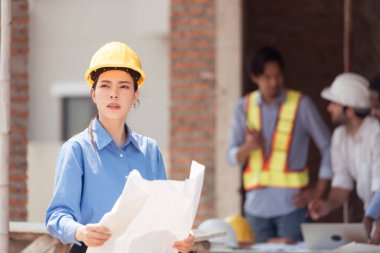 Mühendislerin portresi konut inşaatının ilerlemesini değerlendirmek için birlikte çalışıyor.