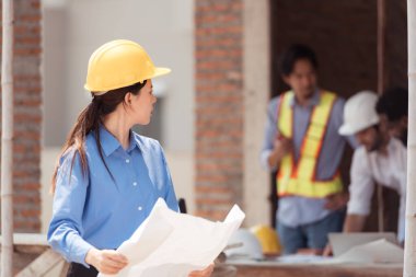 Mühendislerin portresi konut inşaatının ilerlemesini değerlendirmek için birlikte çalışıyor.