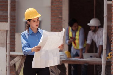 Mühendislerin portresi konut inşaatının ilerlemesini değerlendirmek için birlikte çalışıyor.