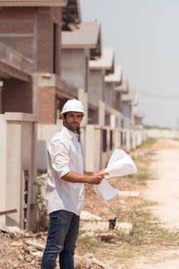 Mühendislerin portresi konut inşaatının ilerlemesini inceler ve değerlendirir.