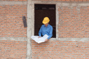 Mühendislerin portresi konut inşaatının ilerlemesini inceler ve değerlendirir.