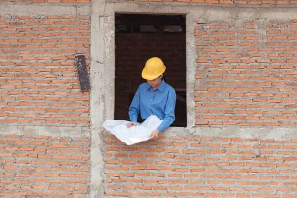 Mühendislerin portresi konut inşaatının ilerlemesini inceler ve değerlendirir.