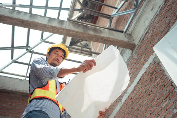 Mühendislerin portresi konut inşaatının ilerlemesini inceler ve değerlendirir.