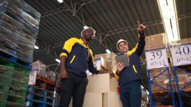 Belgelere dayanarak iki depo çalışanı listeyi inceliyor.