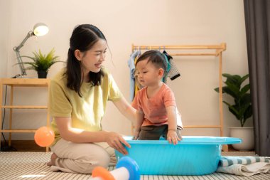Annesiyle kahvaltı yapan küçük çocuk banyo yapmadan önce onu besliyor.