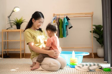 Annesiyle kahvaltı yapan küçük çocuk banyo yapmadan önce onu besliyor.