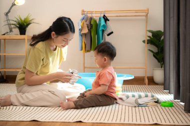 Annesiyle kahvaltı yapan küçük çocuk banyo yapmadan önce onu besliyor.
