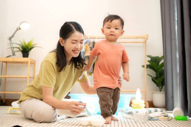 Annesiyle kahvaltı yapan küçük çocuk banyo yapmadan önce onu besliyor.