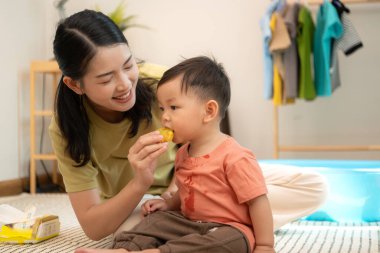Annesiyle kahvaltı yapan küçük çocuk banyo yapmadan önce onu besliyor.