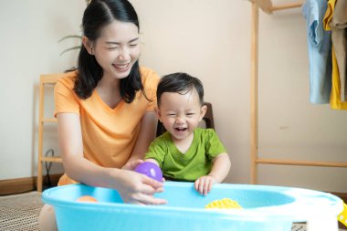 Anne ve küçük çocuk sabahları evde duş alıp giyiniyorlar.