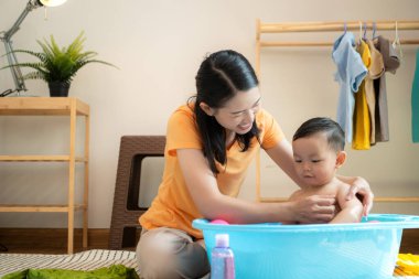 Anne ve küçük çocuk sabahları evde duş alıp giyiniyorlar.