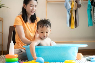 Anne ve küçük çocuk sabahları evde duş alıp giyiniyorlar.