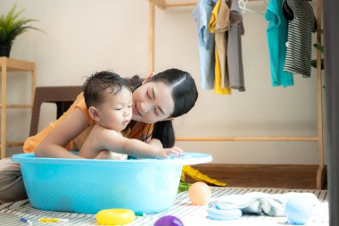 Anne ve küçük çocuk sabahları evde duş alıp giyiniyorlar.