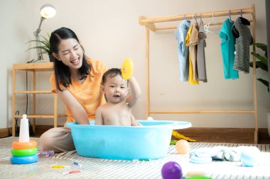 Anne ve küçük çocuk sabahları evde duş alıp giyiniyorlar.