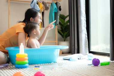 Anne ve küçük çocuk sabahları evde duş alıp giyiniyorlar.