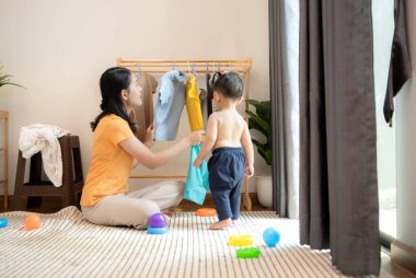 Anne ve küçük çocuk sabahları evde duş alıp giyiniyorlar.