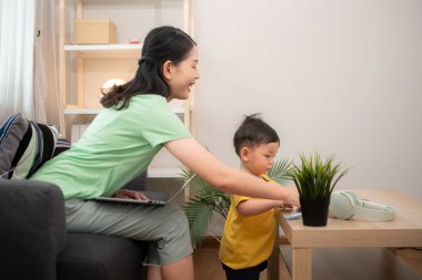 Evde tatildeyken, bir anne küçük bir çocukla ilgilenir.