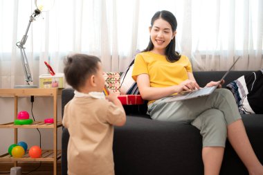 Evde tatildeyken, bir anne küçük bir çocukla ilgilenir.