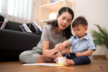 Evde tatildeyken, bir anne küçük çocukla aktiviteler çizer.