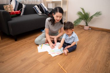 Evde tatildeyken, bir anne küçük çocukla aktiviteler çizer.