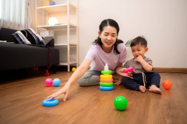 Evde tatildeyken, bir anne küçük bir çocukla ilgilenir.