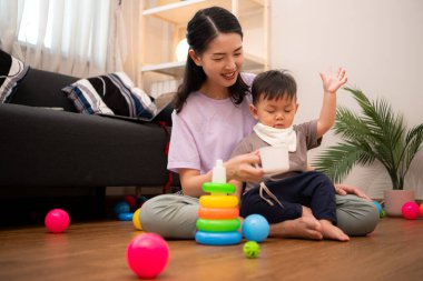 Evde tatildeyken, bir anne küçük bir çocukla ilgilenir.