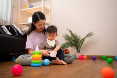 Evde tatildeyken, bir anne küçük bir çocukla ilgilenir.
