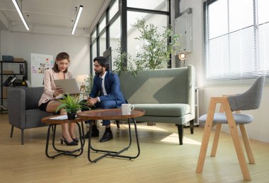 Çağdaş bir ofiste, patron ve asistan bir iş projesinin ilerlemesini izlemek için görevdeler.