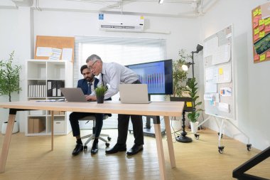 Çağdaş bir ofiste, iki üst düzey yönetici bir iş projesinin ilerleyişini izlemek ve beyin fırtınası yapmak istiyor.