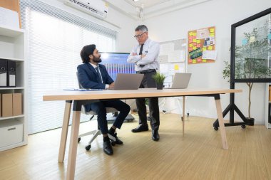 Çağdaş bir ofiste, iki üst düzey yönetici bir iş projesinin ilerleyişini izlemek ve beyin fırtınası yapmak istiyor.