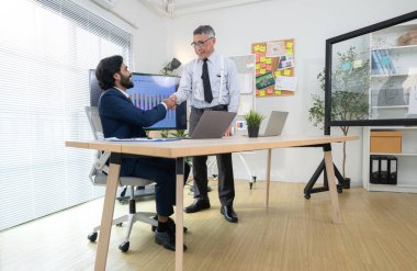 Çağdaş bir ofiste, iki üst düzey yönetici bir iş projesinin ilerleyişini izlemek ve beyin fırtınası yapmak istiyor.