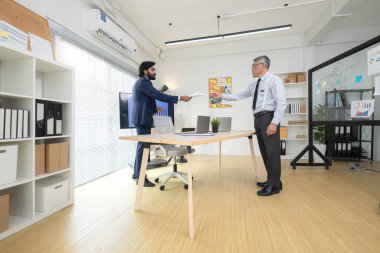 Çağdaş bir ofiste, iki üst düzey yönetici bir iş projesinin ilerleyişini izlemek ve beyin fırtınası yapmak istiyor.