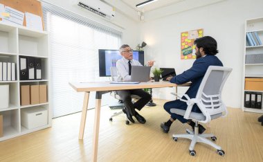 Çağdaş bir ofiste, iki üst düzey yönetici bir iş projesinin ilerleyişini izlemek ve beyin fırtınası yapmak istiyor.