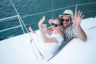 Genç bir çift yatta deniz macerasının tadını çıkarıyor.