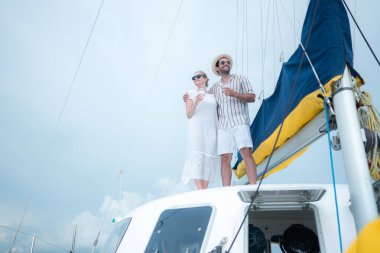 Genç bir çift yatta deniz macerasının tadını çıkarıyor.