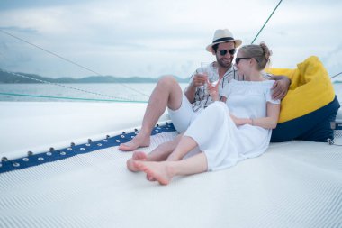 Genç bir çift yatta deniz macerasının tadını çıkarıyor.