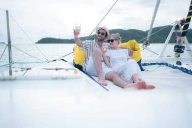 Genç bir çift yatta deniz macerasının tadını çıkarıyor.