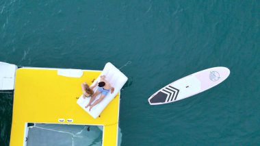 Genç bir çift yatta deniz macerasının tadını çıkarıyor.